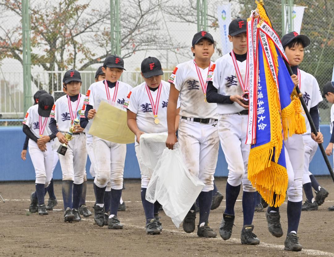 県少年軟式野球選手権大会で優勝し、ダイヤモンドを1周する茎崎ファイターズの選手たち=なかLuckyFM公園野球場