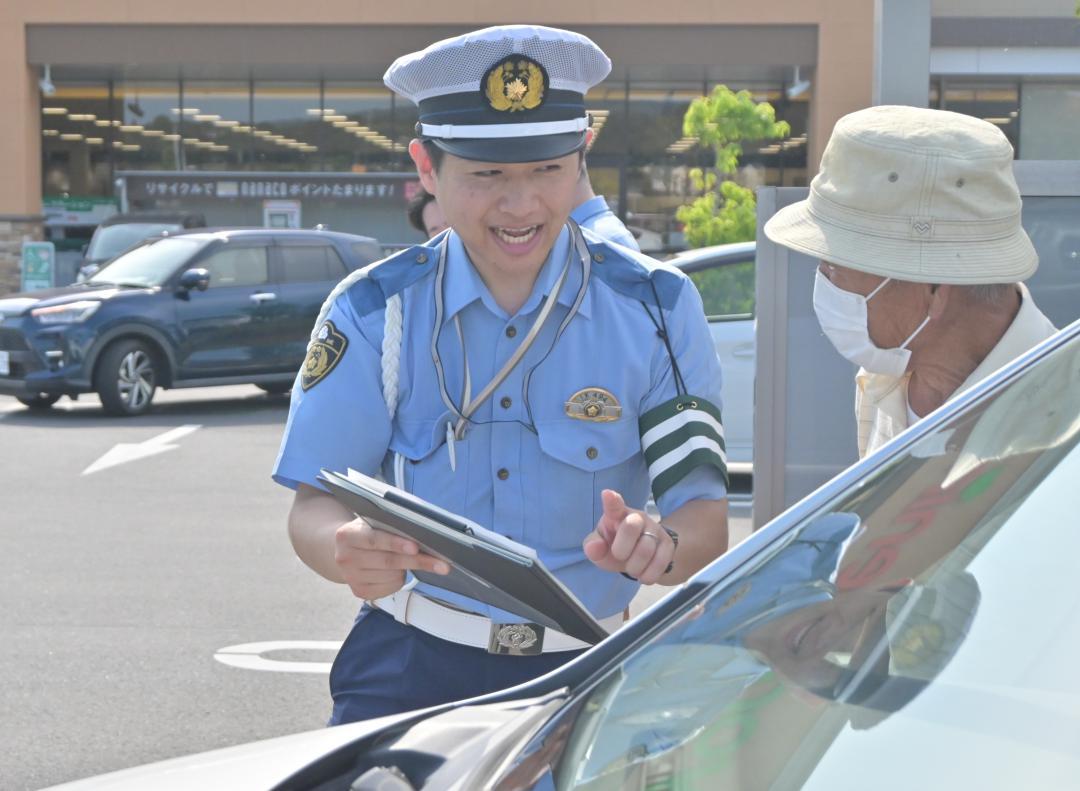 スーパー駐車場で高齢者に事故防止を呼びかける警察官=常陸太田市内