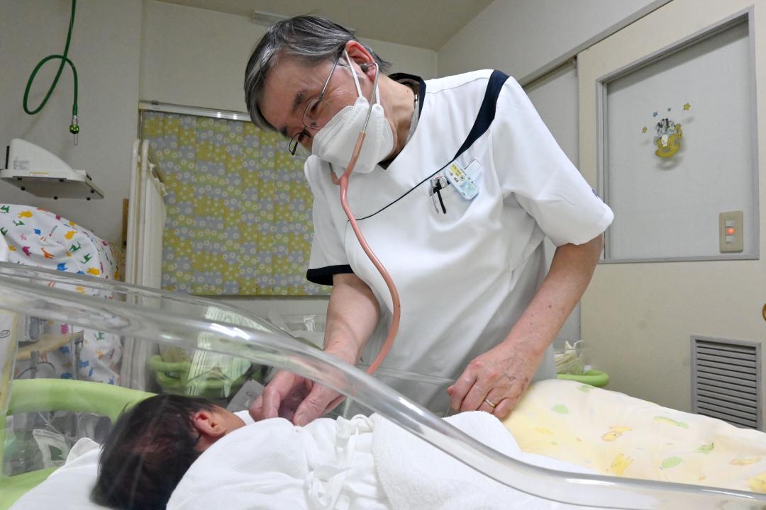 新生児を見る「かんの産婦人科クリニック」の菅野俊一院長。同院でも無痛分娩が増えている=取手市藤代