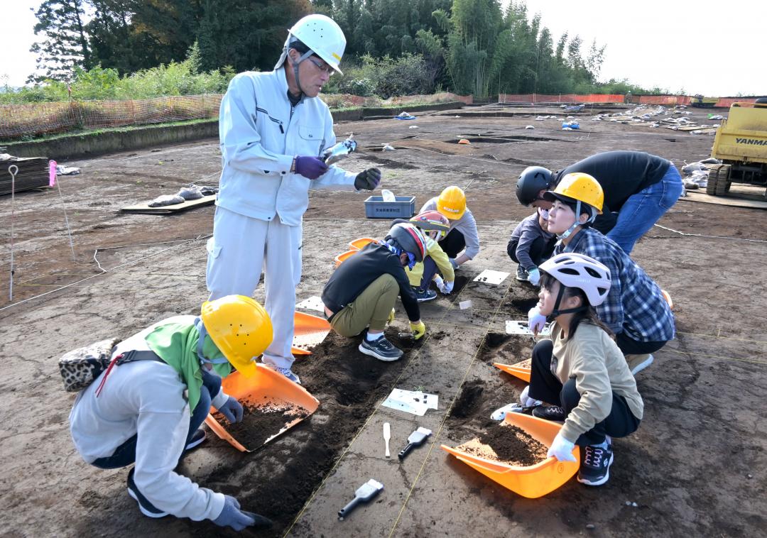 竪穴式住居跡で遺物の発掘体験を行う参加者=土浦市下坂田