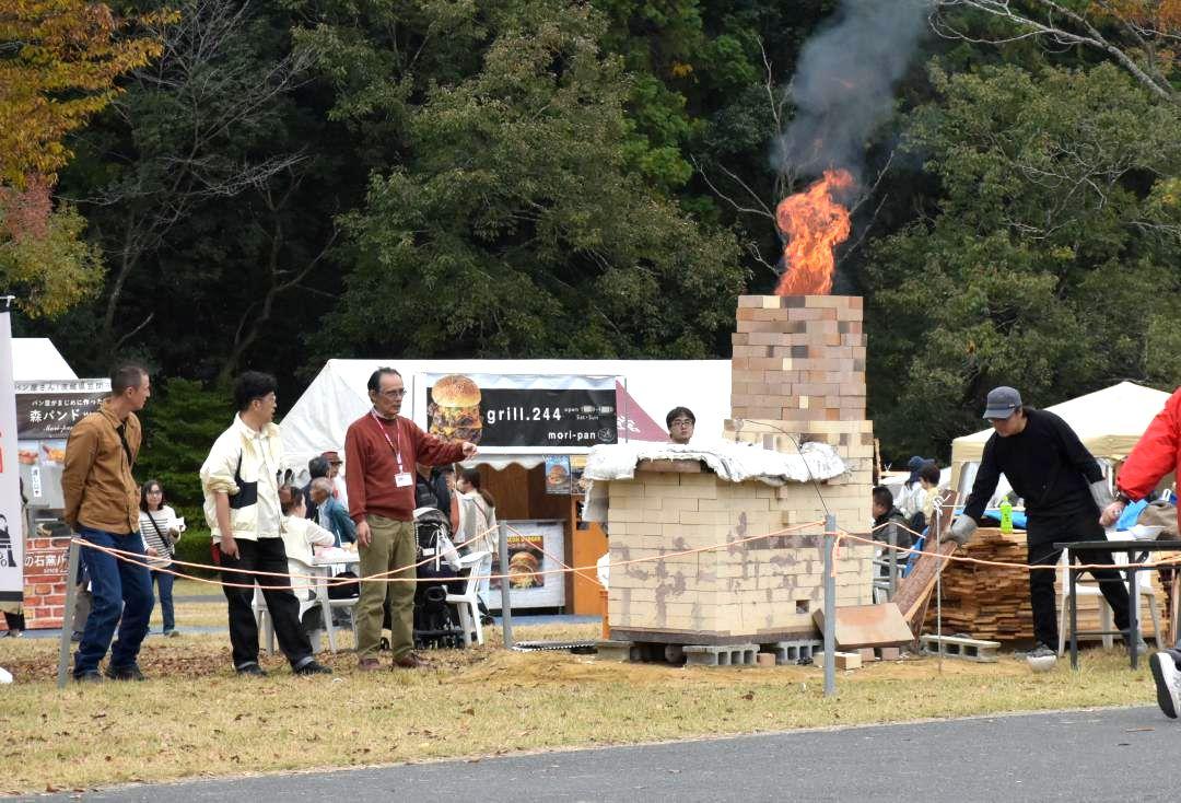 煙突から炎と煙を上げるまき窯=笠間市笠間