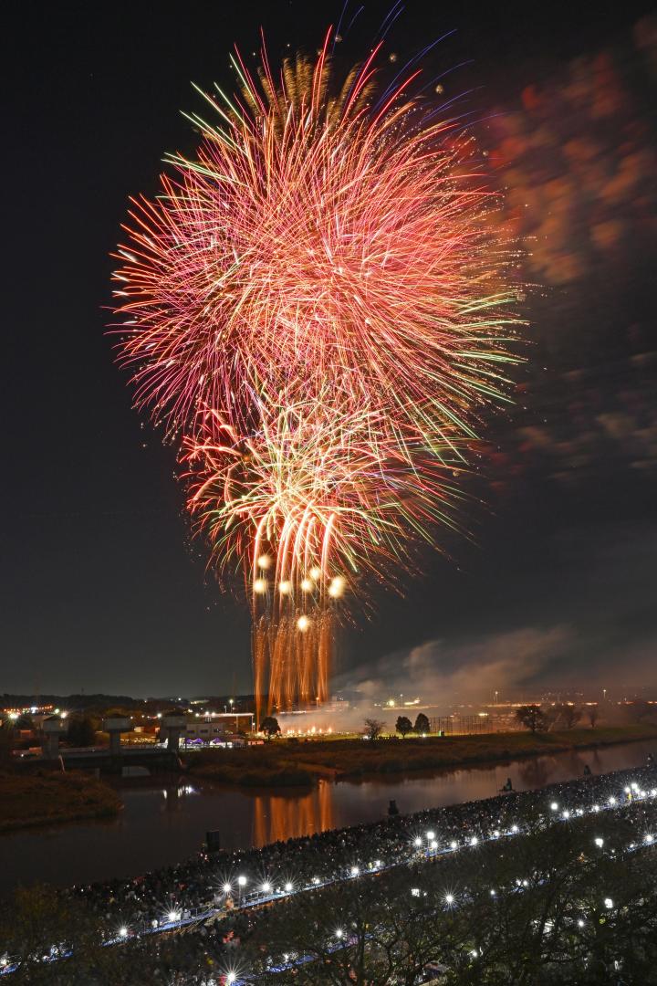 土浦全国花火競技大会で会場を彩るスターマイン=1日、土浦市の桜川畔