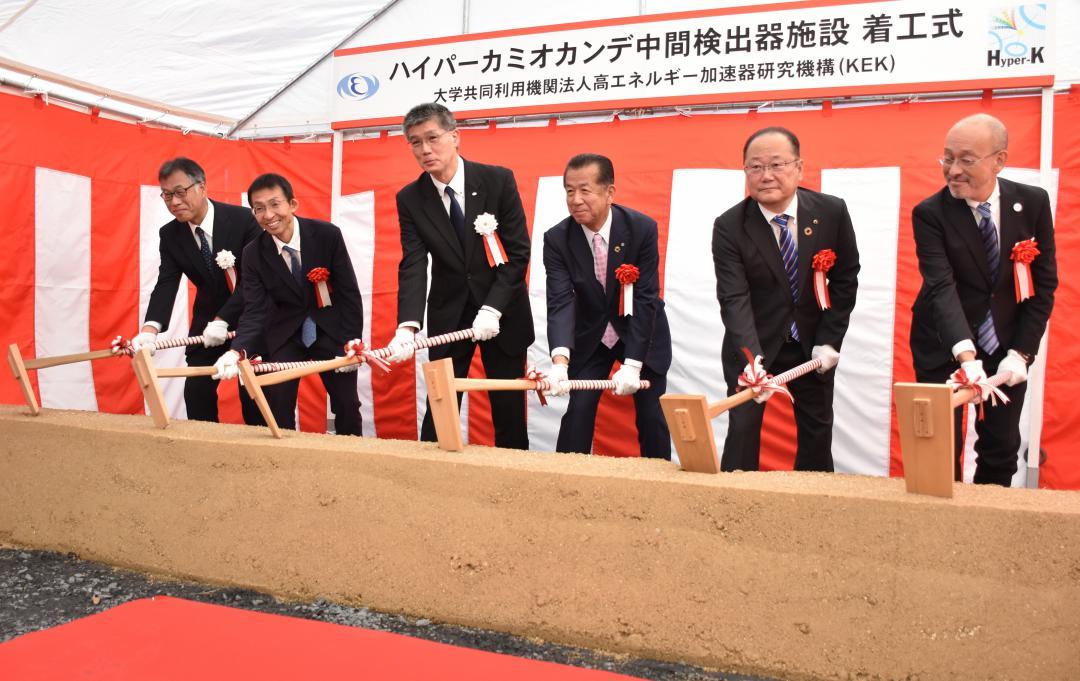 くわ入れを行う高エネルギー加速器研究機構の浅井祥仁機構長(左から3人目)ら=東海村村松