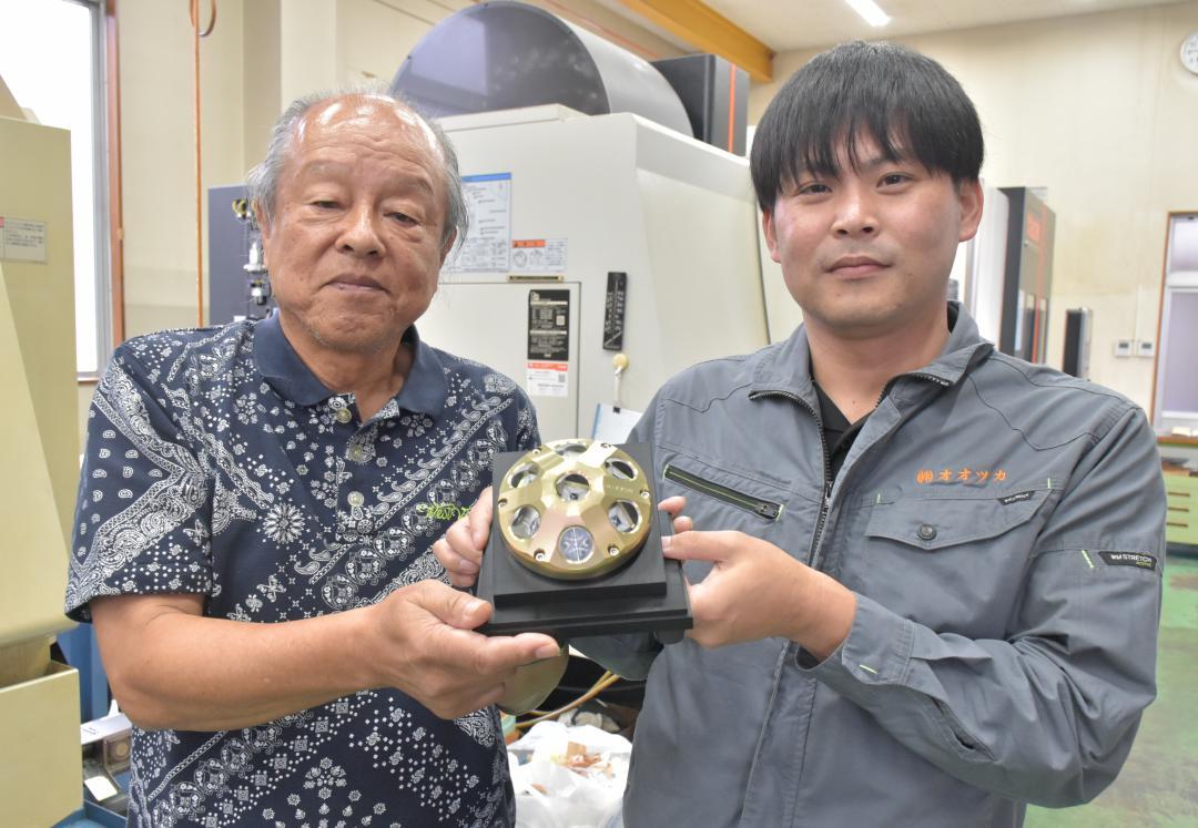 JAXAから技術移転を受けたオオツカの大塚美智夫社長(左)ら=つくば市大曽根