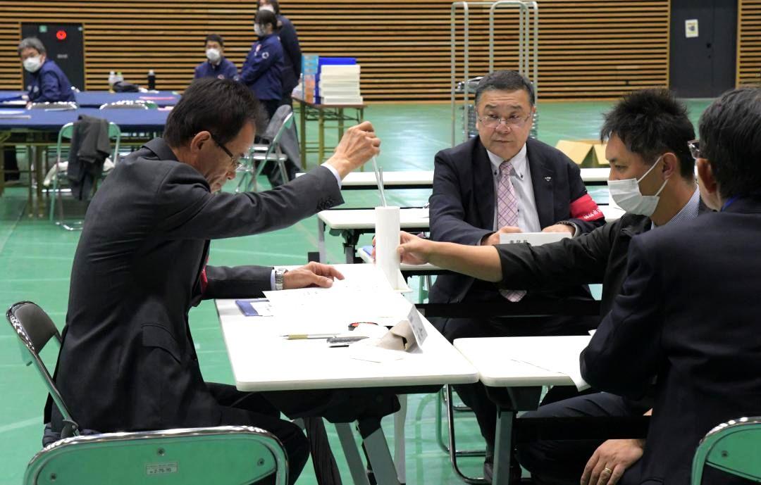 くじを引く境政一選挙長(左)=9日午後10時2分、神栖市木崎