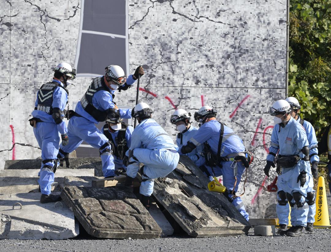倒壊したビルのがれきを撤去する消防隊員=ひたちなか市新光町のひたちなか地区多目的広場