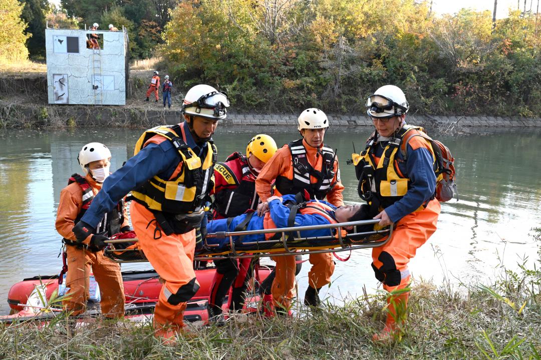 水害で孤立した家屋からレスキューボートで救助し、全地形対応車（バギー）まで運ぶ消防隊員ら＝ひたちなか市東石川の陸上自衛隊勝田小演習場
