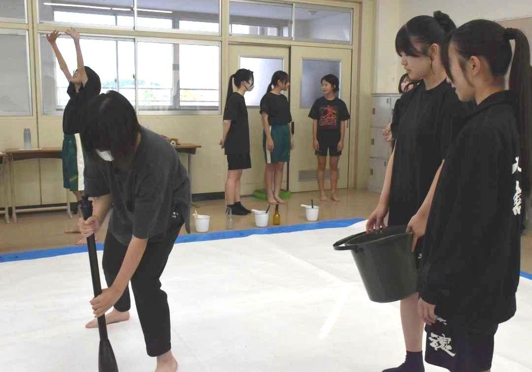 書道パフォーマンスの練習をする水戸英宏中の生徒(左)=水戸市見川町