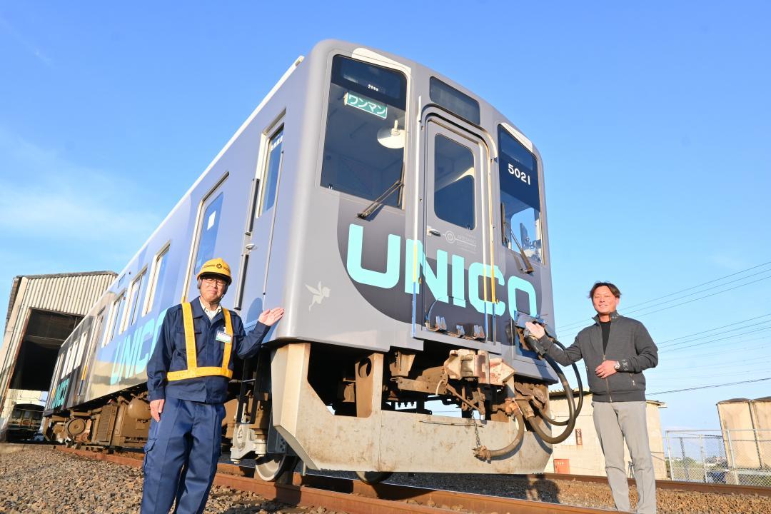 フルラッピング列車をアピールする若生哲史CEO(右)=常総市水海道高野町