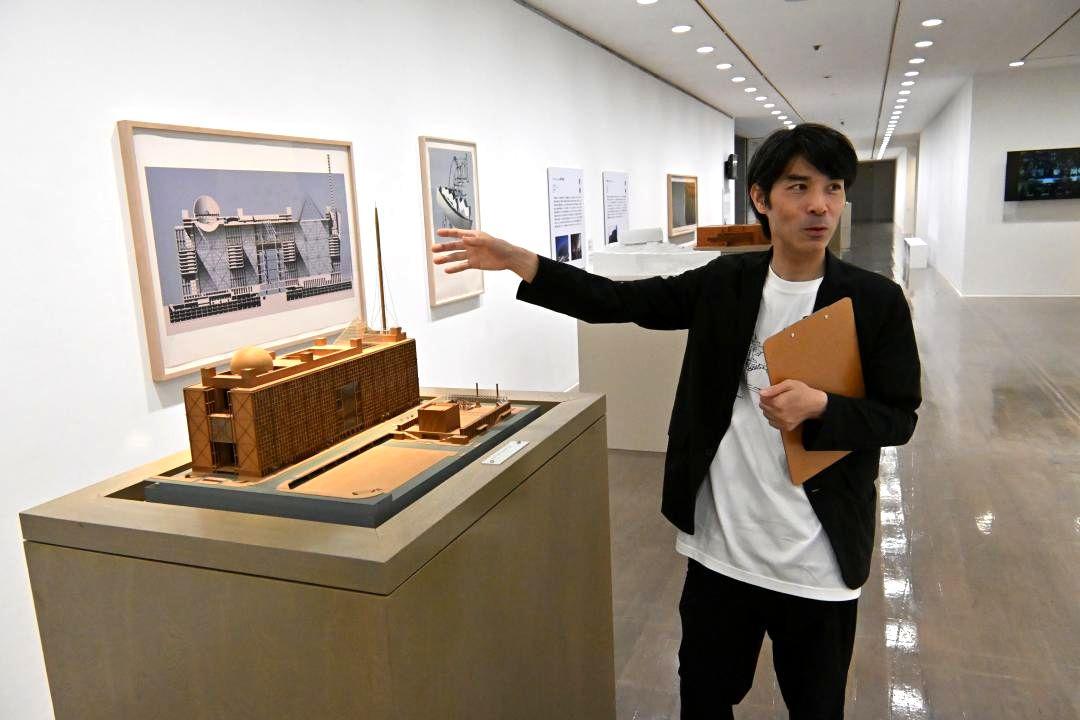 磯崎新さんが手がけた建築作品を紹介する水戸芸術館の井関悠主任学芸員=水戸市五軒町