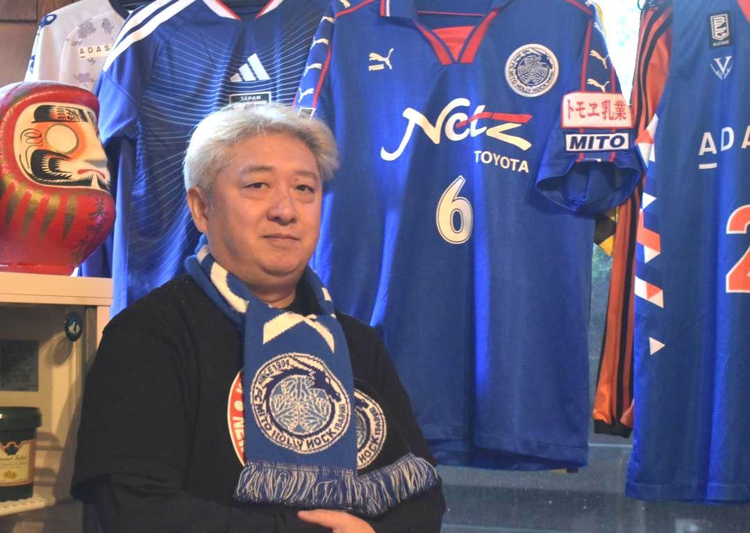 J2水戸の選手らと交流を続けてきた洋食店「レストラン　マロン」の大塚巌さん。店内にはユニホームが並ぶ=水戸市五軒町