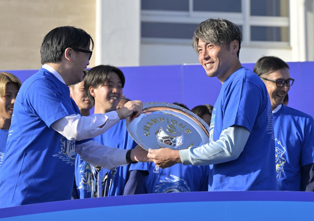 水戸ホーリーホックの小島耕社長(左)から本物の優勝シャーレを受け取る主将の松原修平選手=30日午後、水戸市三の丸