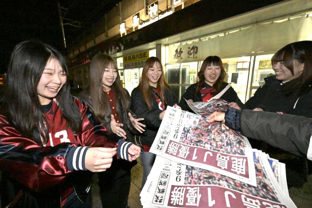 号外を手に取る鹿島サポーター=6日午後6時ごろ、鹿嶋市宮下