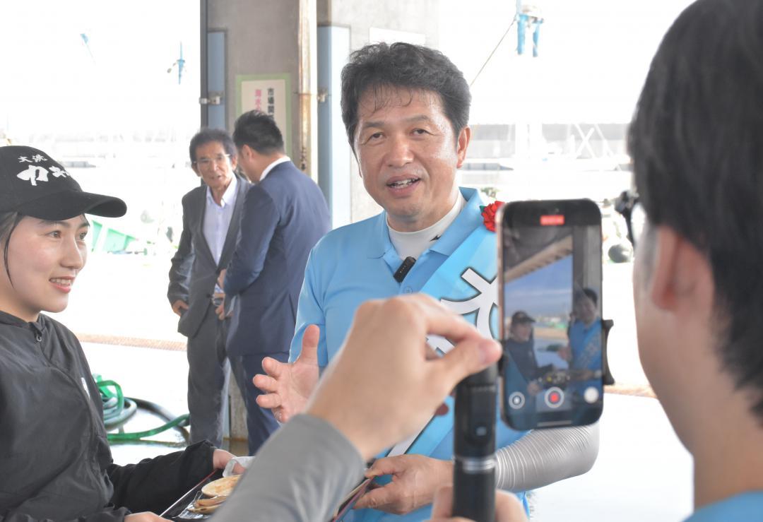 知事選の遊説先でSNSへの投稿用動画を撮影する大井川和彦氏=8月21日、大洗町磯浜町