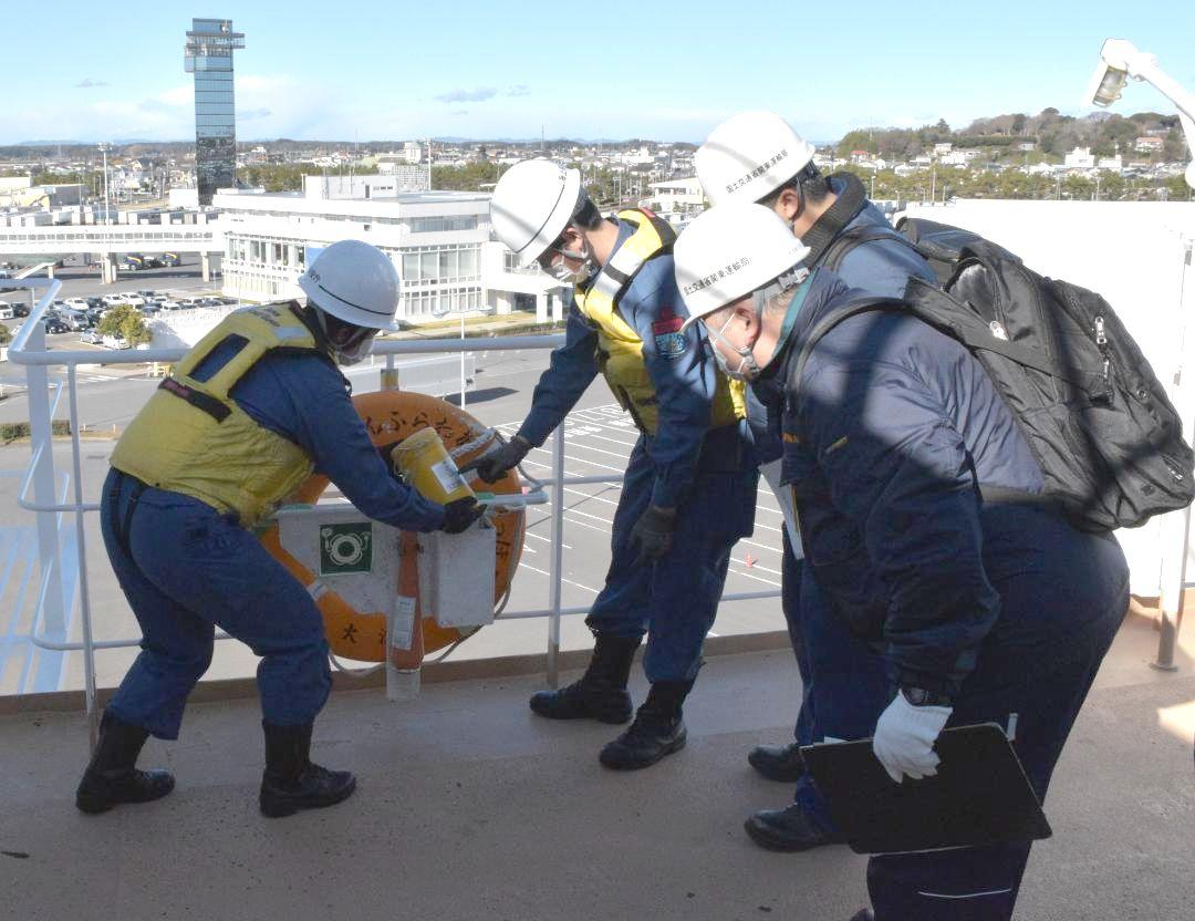 デッキに設置された救命浮輪の点検を行う職員ら=大洗町港中央