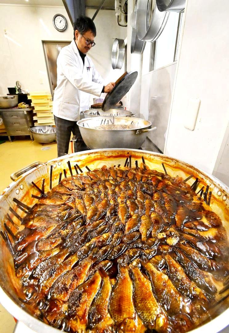 最盛期を迎えたフナの甘露煮作り。大鍋に並べられたフナは長時間煮込まれ、あめ色になった=古河市本町