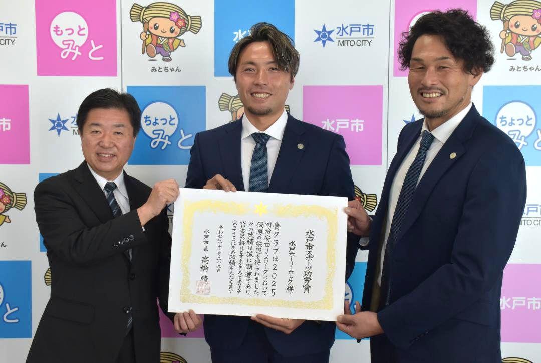 水戸ホーリーホックへの水戸市スポーツ功労賞の授与式に臨んだ(左から)高橋靖市長と松原修平選手、本間幸司CRO=同市役所