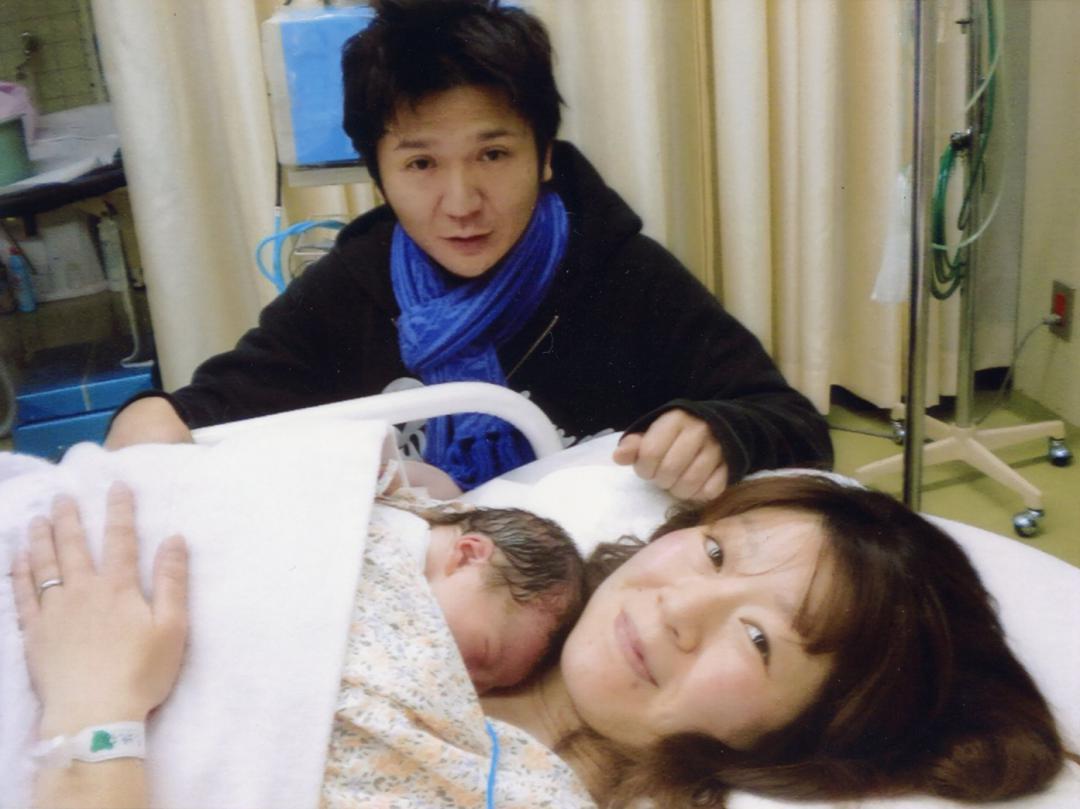 東日本大震災が発生した2011年3月11日に、生まれたばかりの菫さんを抱く母親の志穂さん(本人提供)