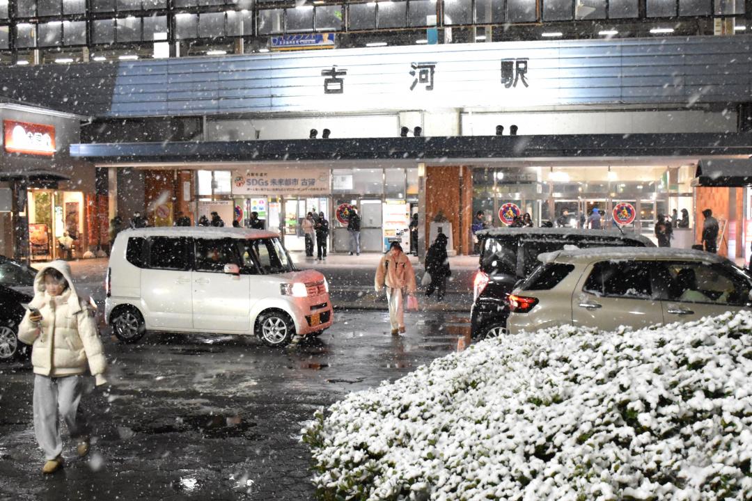 降雪の中を歩くJR古河駅利用者ら=2日午後6時51分ごろ、同駅東口前