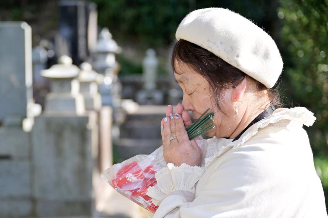 自宅近くの墓地で手を合わせる守家文子さん=いずれも福島県双葉町