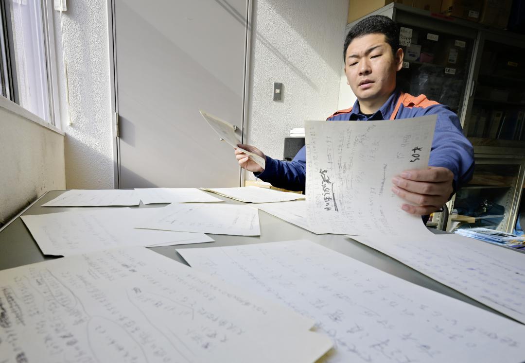 東日本大震災当時、通信指令室だった部屋で「避難命令」の文言を走り書きしたメモを見返す大洗町消防本部の増田裕太さん=同町磯浜町