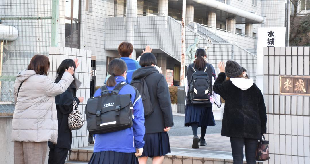 試験会場に向かう受験生と手を振って見送る保護者ら=9日午前7時50分ごろ、水戸市白梅