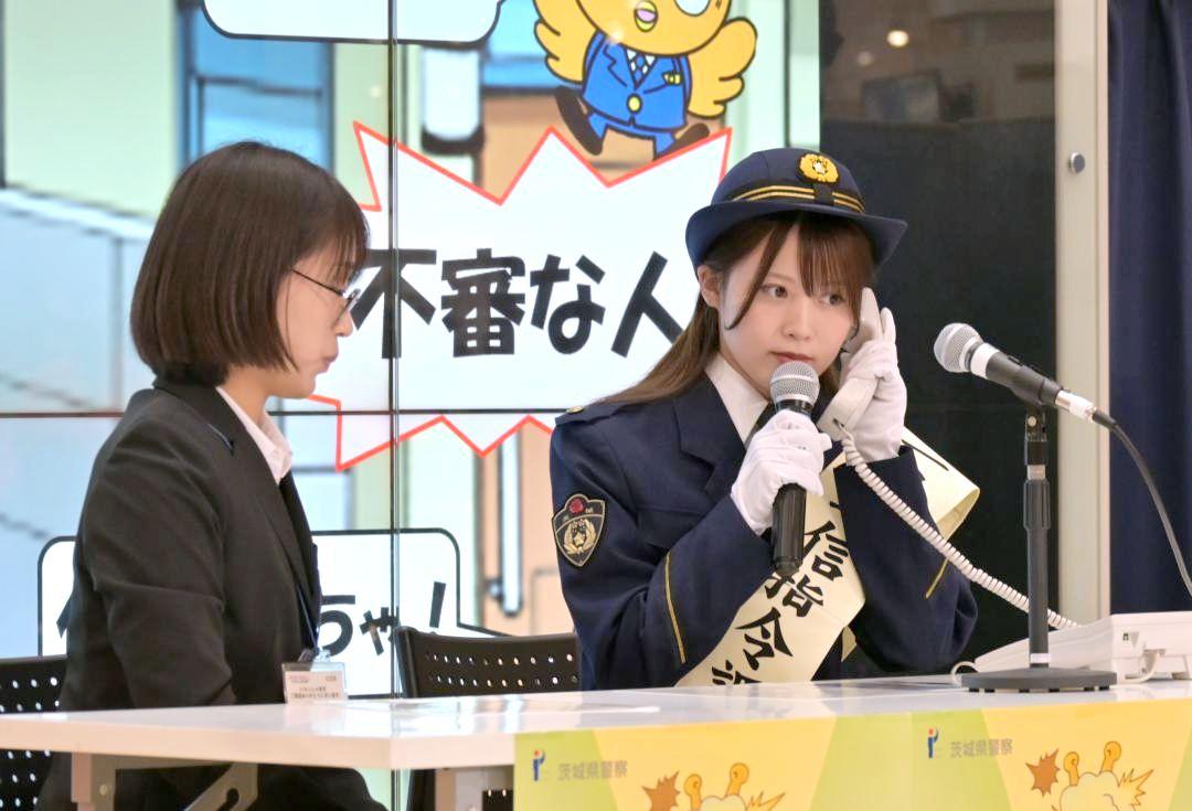 模擬110番通報を体験する一日通信指令課長の岡部麟さん(右)=水戸市内原