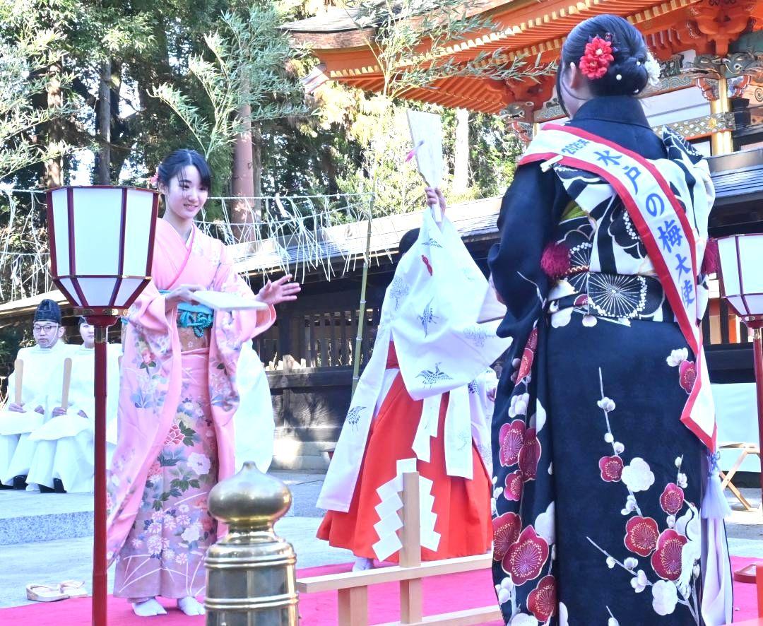 羽根突き奉納を行う新成人の山本寧々さん(左)と水戸の梅大使ら=水戸市八幡町