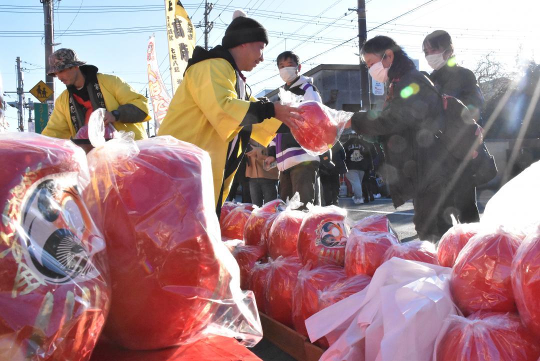縁起物のだるまを買い求める市民=筑西市甲