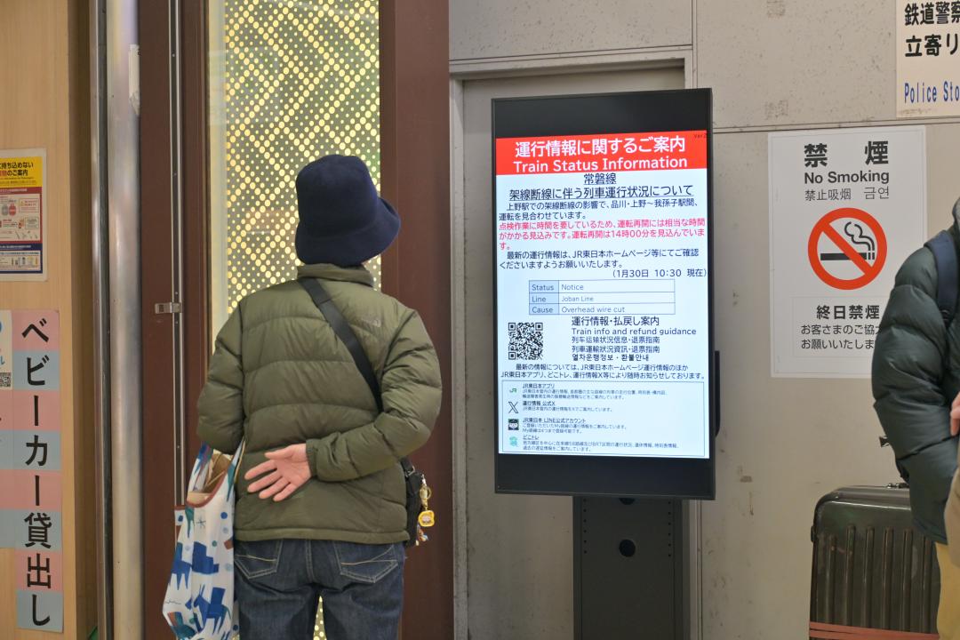 運行情報を伝える電光掲示板を確認する駅利用者=JR水戸駅構内