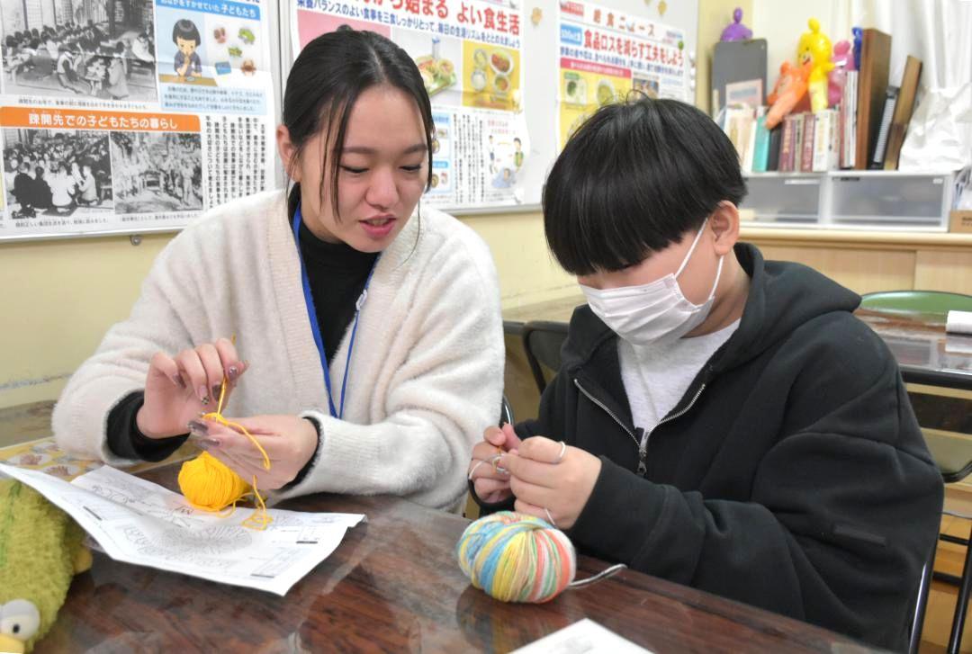 学習支援サポーター(左)と手芸品の制作に挑戦する生徒=日立市城南町