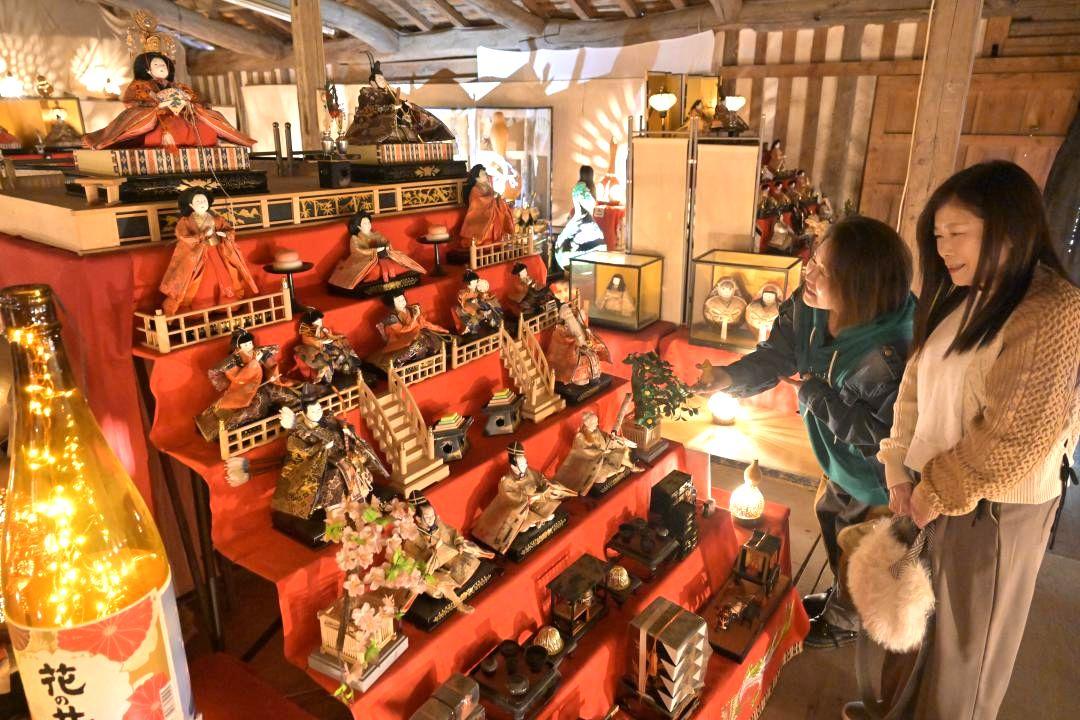 真壁のひなまつりが開幕し、西岡本店の「樽蔵」に並ぶひな人形を楽しむ観光客ら=桜川市真壁町田