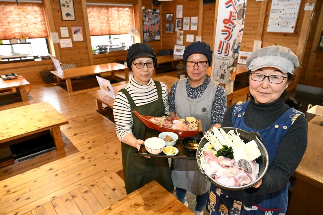 この時期に人気の「どぶ汁風あんこう鍋」を持ち、ほほ笑む村山文恵店主(右)と従業員ら=北茨城市大津町五浦