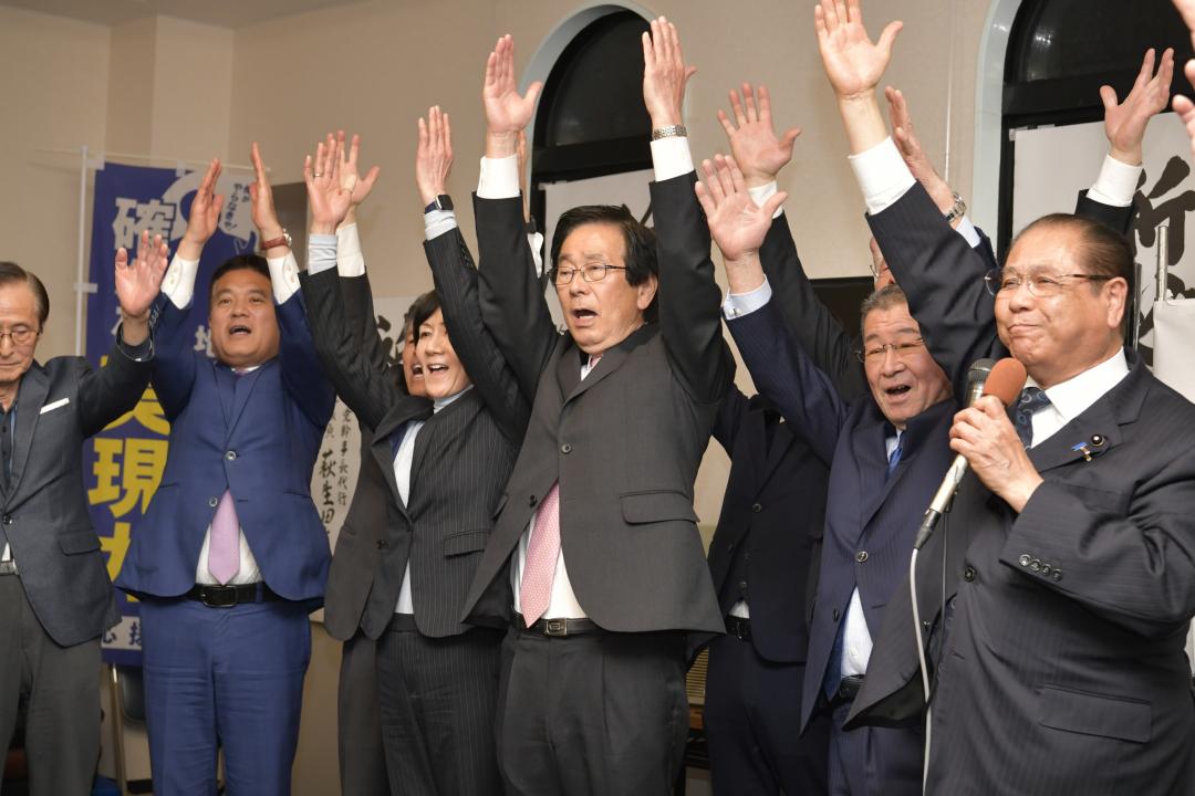 小選挙区での当選を確実にし、支持者とともに万歳する田所嘉徳氏(中央)=水戸市元吉田町