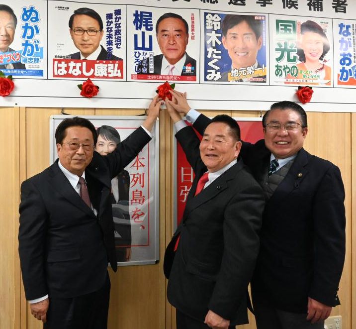 候補者ボードに当選を示す赤い造花を付ける自民党県連の海野透会長(中央)と白田信夫幹事長(左)、伊沢勝徳政調会長=8日深夜、水戸市笠原町