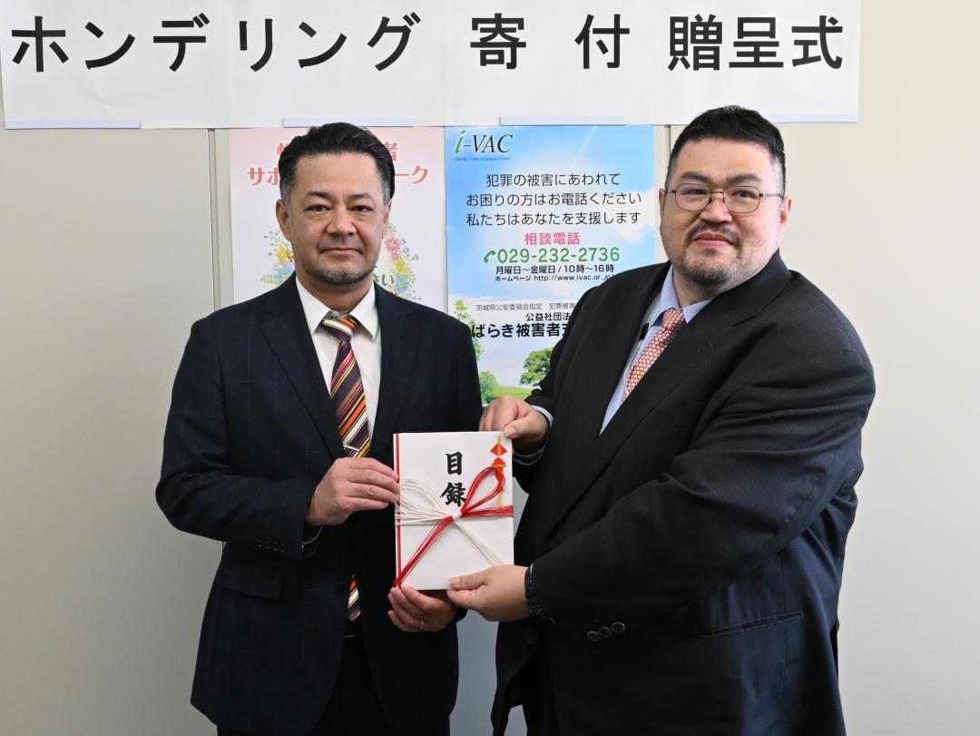 いばらき被害者支援センターの千手正治副理事長(右)に目録を手渡すNTT東日本茨城支店の小谷浩之企画総務部長=水戸市柵町