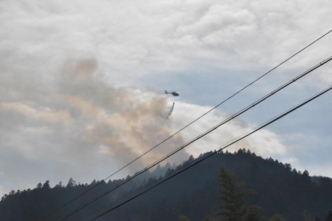消火活動をするヘリ＝20日午前11時14分、常陸太田市