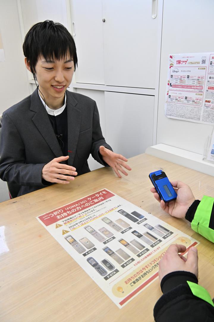 NTTドコモのFOMA終了について説明するドコモショップの店員=水戸市内