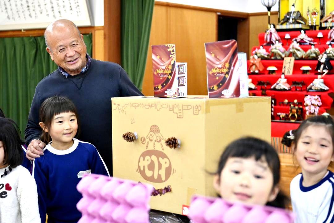 大震災当時に避難場所になったホールで、子どもたちに囲まれ笑顔を見せる橋本隆さん=潮来市日の出(画像の一部を加工しています)