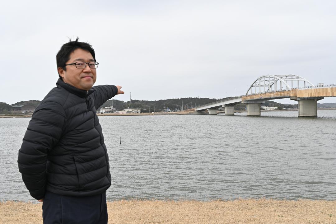 北浦の湖畔で旧鹿行大橋が崩落した当時を語る日向寺護さん=鉾田市札