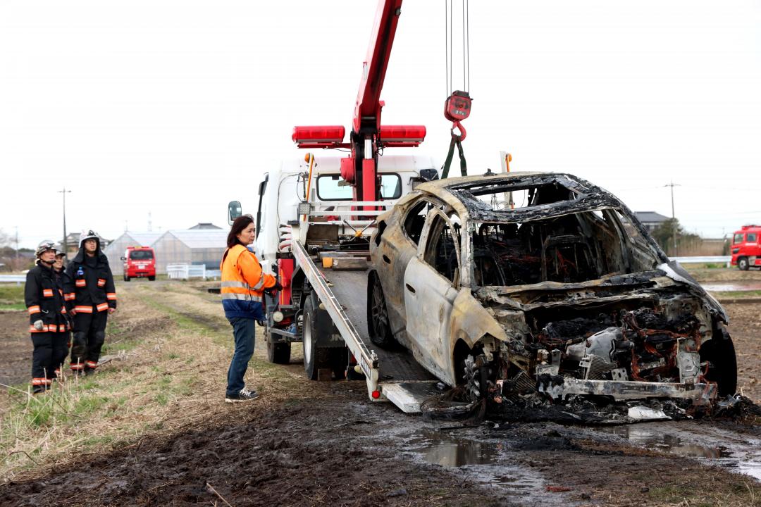 内部から2人の遺体が見つかりレッカー車に載せられる乗用車=稲敷市手賀組新田