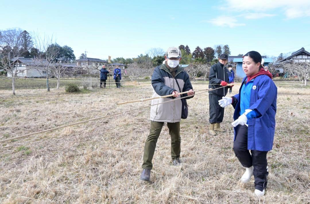 十字に張った水縄の長さを間竿で測る市民と学生=那珂市下江戸