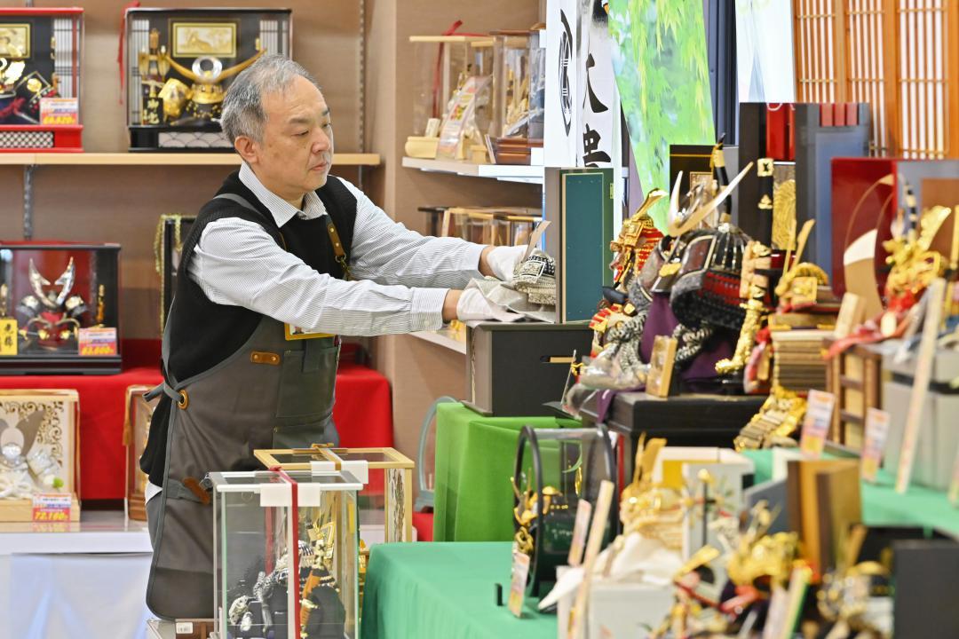 五月人形を飾り付ける「なるしまバッグ人形店」の成嶋英貴さん=龍ケ崎市