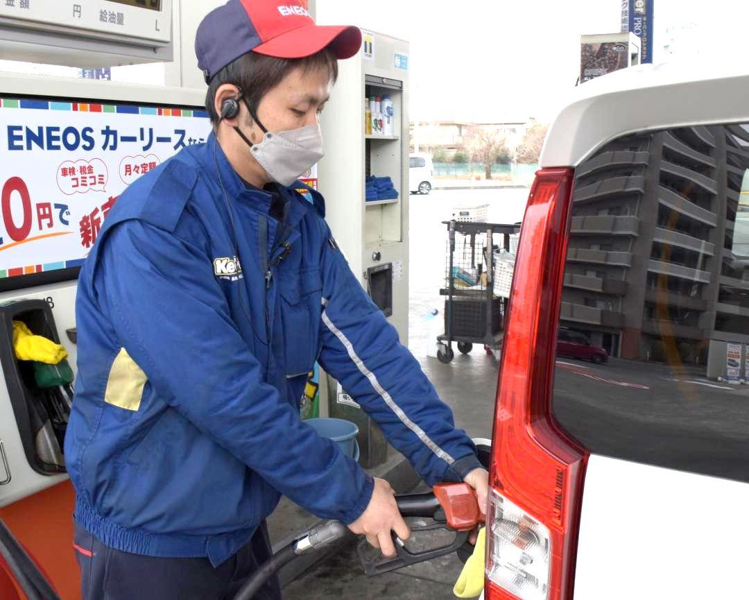 1リットル188円のレギュラーガソリンを給油する青木俊輔店長=16日、水戸市赤塚