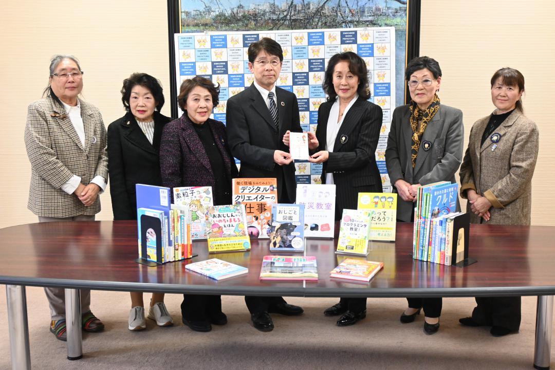 戸祭勝典館長(中央)に目録を手渡す加藤紀子会長(右から3人目)ら=水戸市三の丸