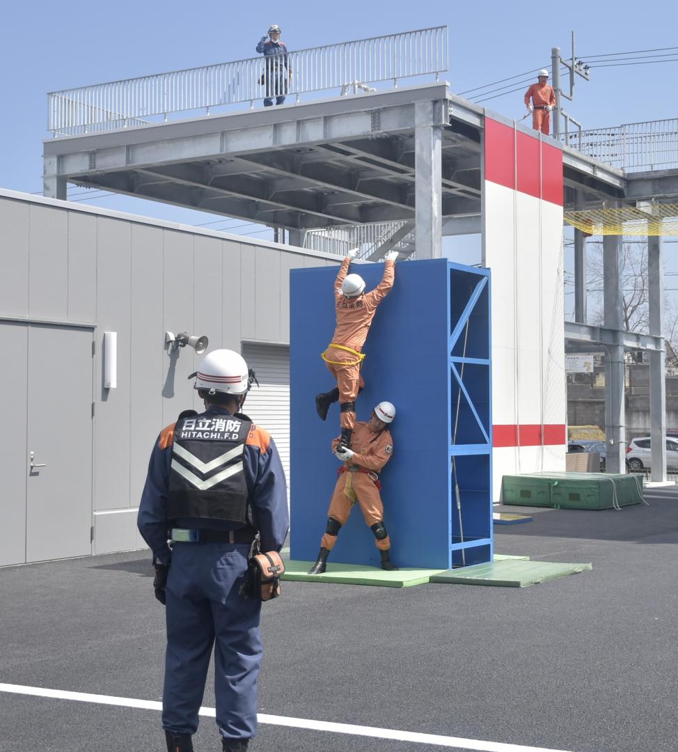 新しい施設で訓練の様子を披露する消防隊員=日立市日高町