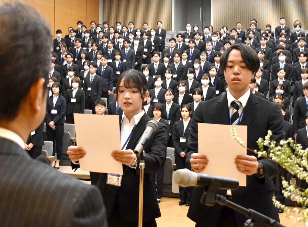 新規採用職員代表として登壇し、宣誓する宮下哲禎さん(右)と清水花乃さん=県庁