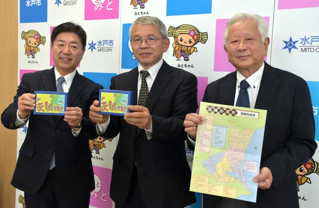 「茨城かるた」を高橋靖水戸市長に託したトムクックの久野勝敬さん、戸田武志さん(左から)=同市役所