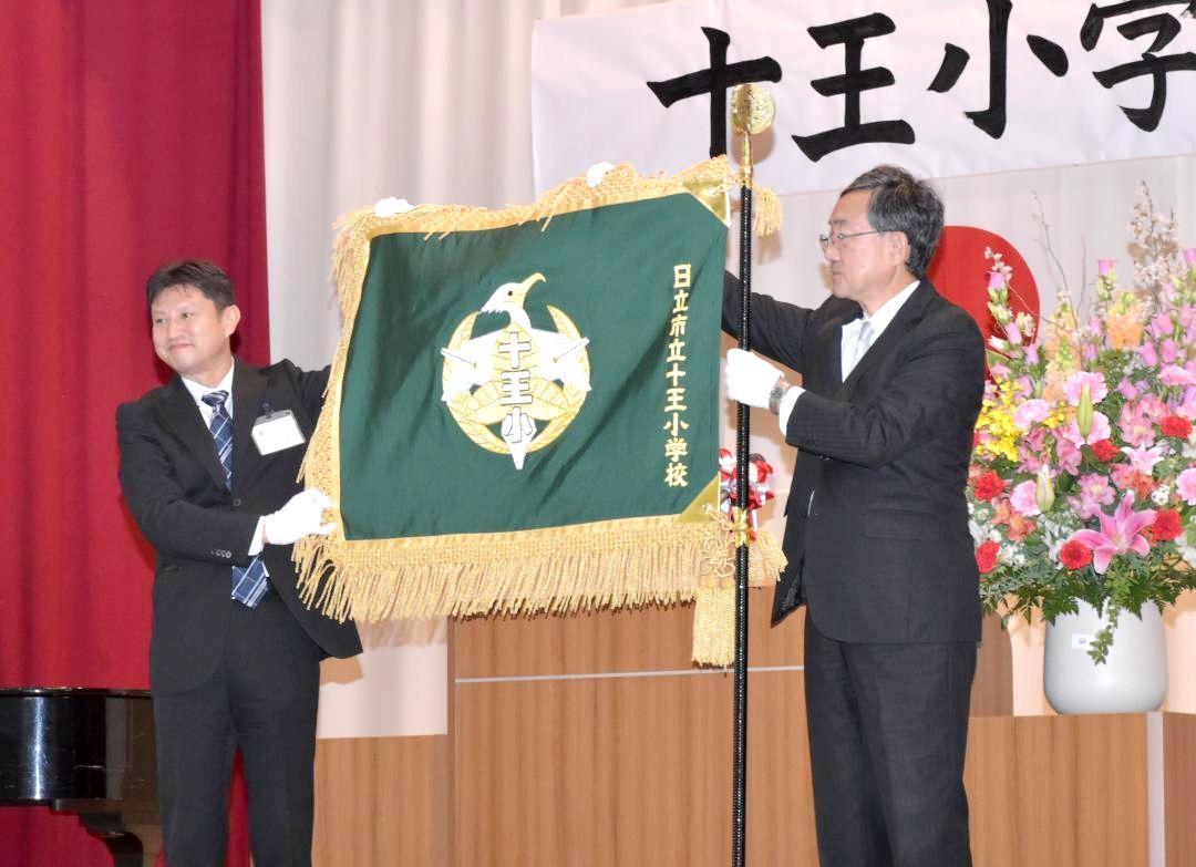 開校式では新しく作られた十王小の校旗が披露された=日立市十王町伊師本郷