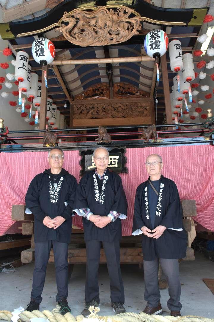 修復を目指す旧助川西上町の舞屋台と豊田和明会長(中央)ら保存会メンバー=日立市鹿島町